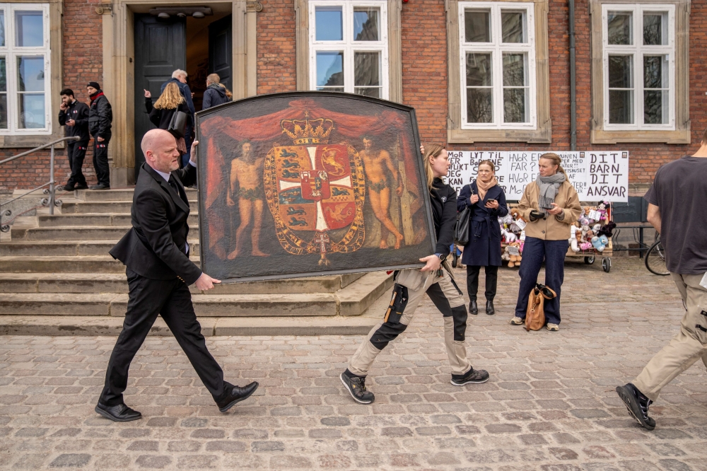 People carry a historic painting out of the Old Stock Exchange, Boersen, during a fire in the historic building, in Copenhagen, Denmark, April 16, 2024. — Ritzau Scanpix/Ida Marie Odgaard pic via Reuters 