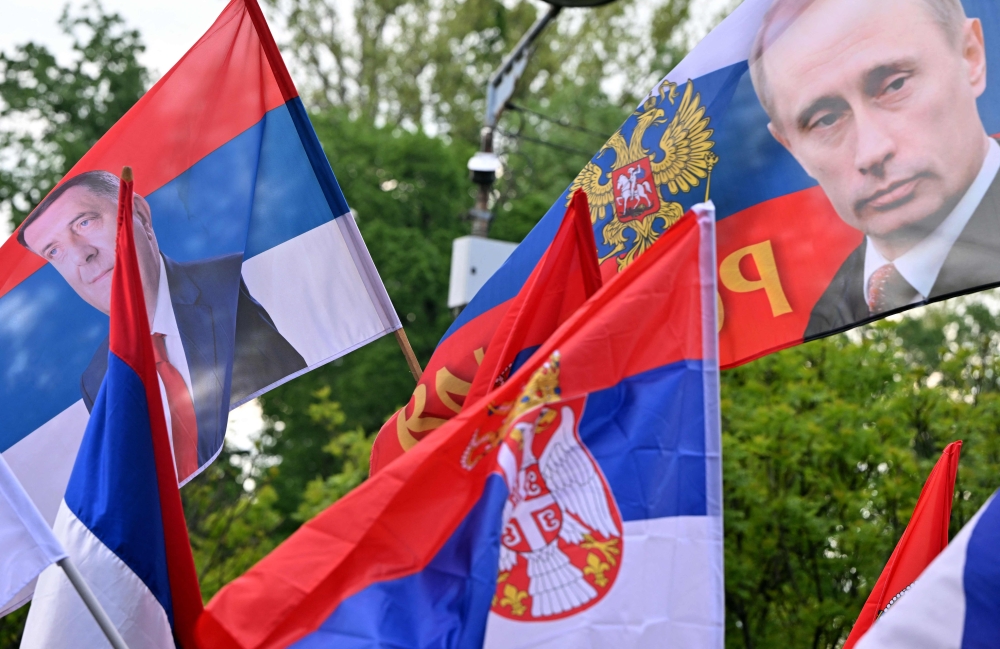 Supporters waves the Serbian with an image of Bosnian Serb secessionist leader Milorad Dodik and a Russian flag with the image of Russian President Vladimir Putin during the 
