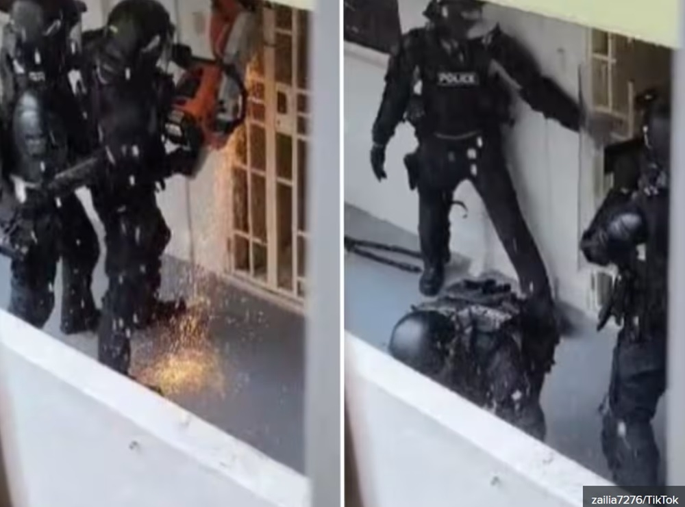 A screen grab of a TikTok video from user ‘zailia7276’ showing Singaporean police officers using a saw to breach a residential unit's main gate before entering. — Picture via TikTok/zailia7276