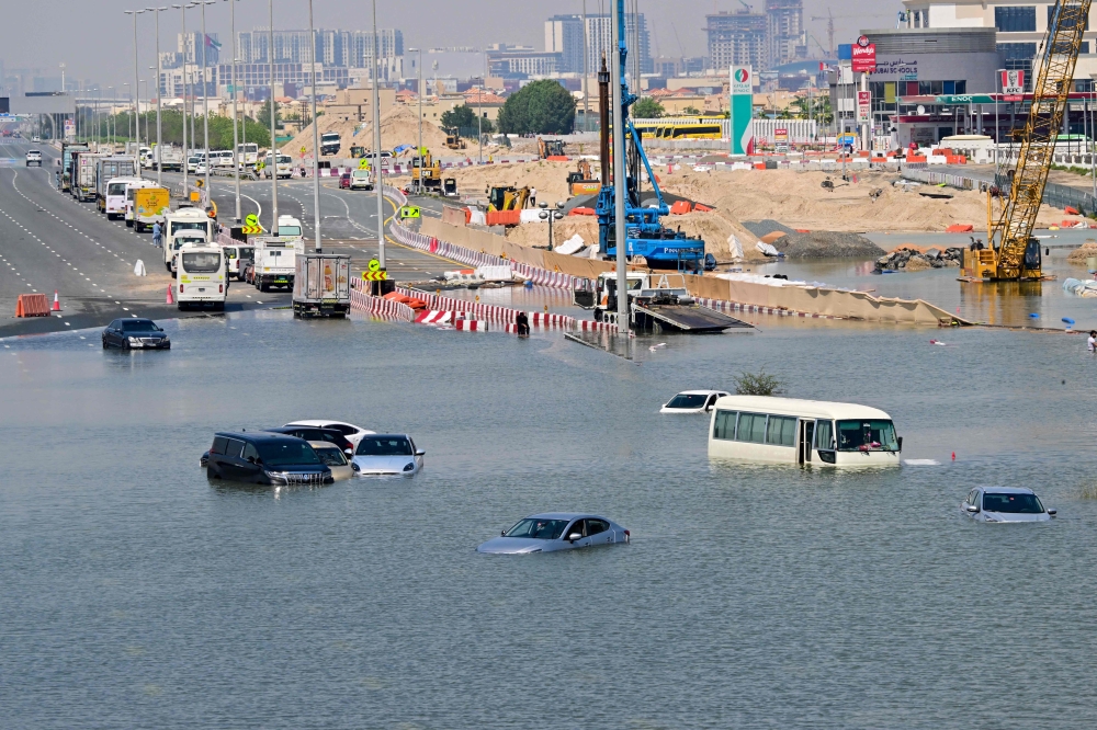 Cars are stranded on a flooded street in Dubai following heavy rains on April 18, 2024. Three workers from the Philippines have died in heavy flooding. — AFP pic