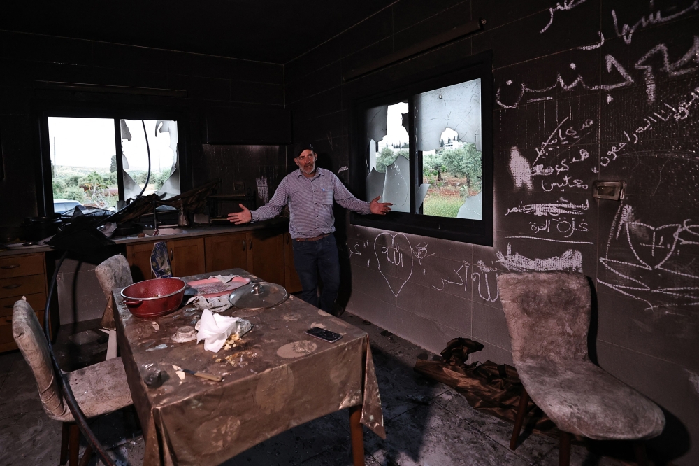 A Palestinian man gestures as he stands inside his kitchen in the aftermath of an attacked by Israeli settlers in occupied West Bank village of Al-Mughayyir near Ramallah April 17, 2024. — AFP pic