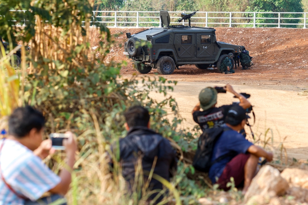Thai soldiers and members of the media take cover near the 2nd Thailand-Myanmar Friendship Bridge during fighting on the Myanmar side between the Karen National Liberation Army (KNLA) and Myanmar's troops, which continues near the Thailand-Myanmar border, in Mae Sot, Tak Province, Thailand, April 20, 2024. ― Reuters pic