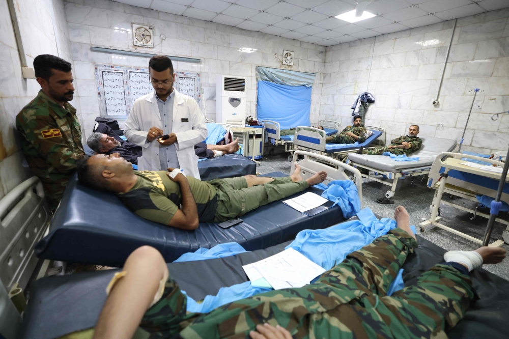 Iraqi military personnel receive treatment at a hospital in Hilla in the central province of Babylon after they were wounded in an alleged bombing overnight on an Iraqi military base housing a coalition of pro-Iranian armed groups, on April 20, 2024. ― AFP pic