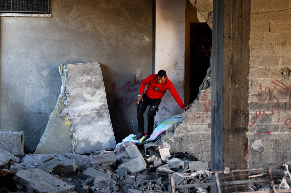 A Palestinian man checks the rubble of a house hit by overnight Israeli bombing in Rafah in the southern Gaza Strip on April 20, 2024, amid the ongoing conflict between Israel and the Hamas movement. ― AFP pic