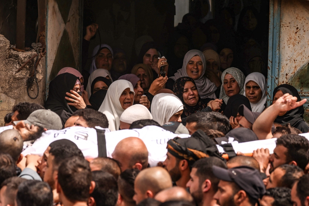 Women react as Mourners carry the body of one of two Palestinian men, reportedly killed during an Israeli settlers’ attack on the village of Aqraba in the Israeli-occupied West Bank, during their funeral procession on April 20, 2024. ― AFP pic