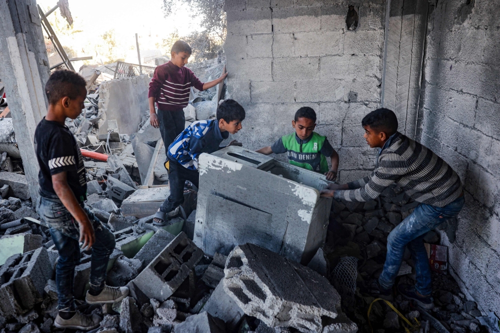 Palestinian children salvage objects from the rubble of a home hit by overnight Israeli bombing in Rafah in the southern Gaza Strip on April 20, 2024, amid the ongoing conflict between Israel and the Hamas movement. ― AFP pic