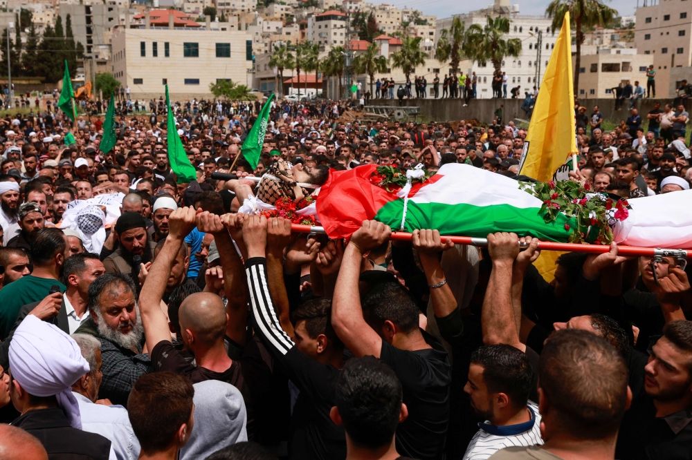 Mourners carry the bodies of  one of two Palestinian men, reportedly killed during an Israeli settlers' attack on the village of Aqraba in the Israeli-occupied West Bank, during their funeral procession on April 20, 2024. ― AFP pic