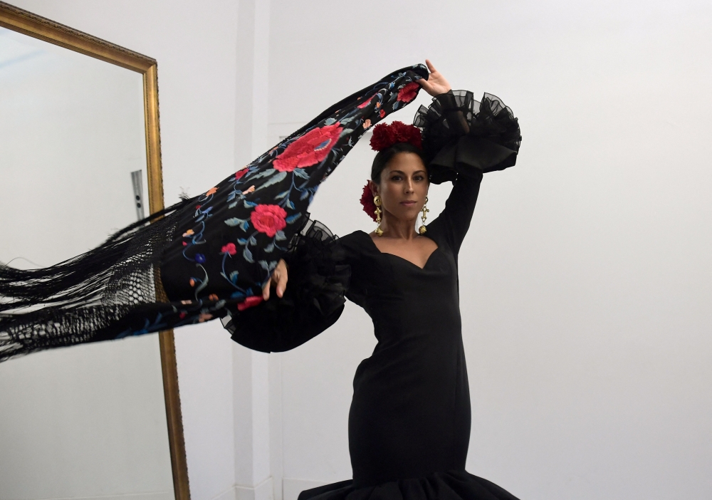 Customer Virginia Cuaresma tries on a flamenco dress at Luis Fernandez' workshop in Seville on April 8, 2024. — AFP pic