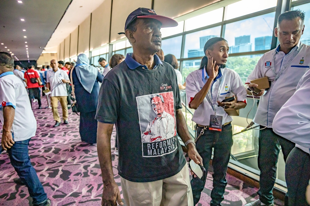 A supporter wears a t-shirt with the image of PKR president Datuk Seri Anwar Ibrahim as they attend the PKR 25th Anniversary Special Convention at IDCC Shah Alam, Selangor April 21, 2024. — Picture by Firdaus Latif