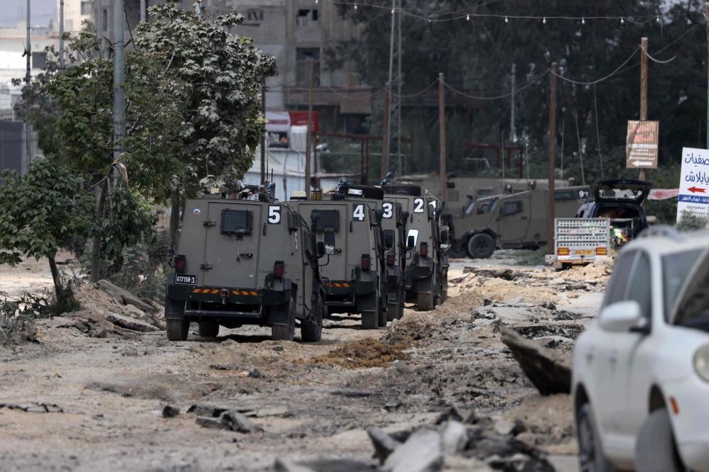 Israeli military vehicles drive along a devastated street in the Nur Shams refugee camp in the occupied West Bank, during a raid on April 19, 2024. — AFP pic