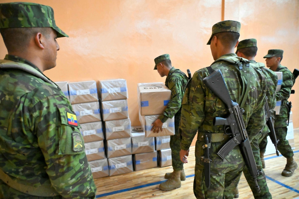 Soldiers distribute electoral material at a school in Quito. — AFP pic