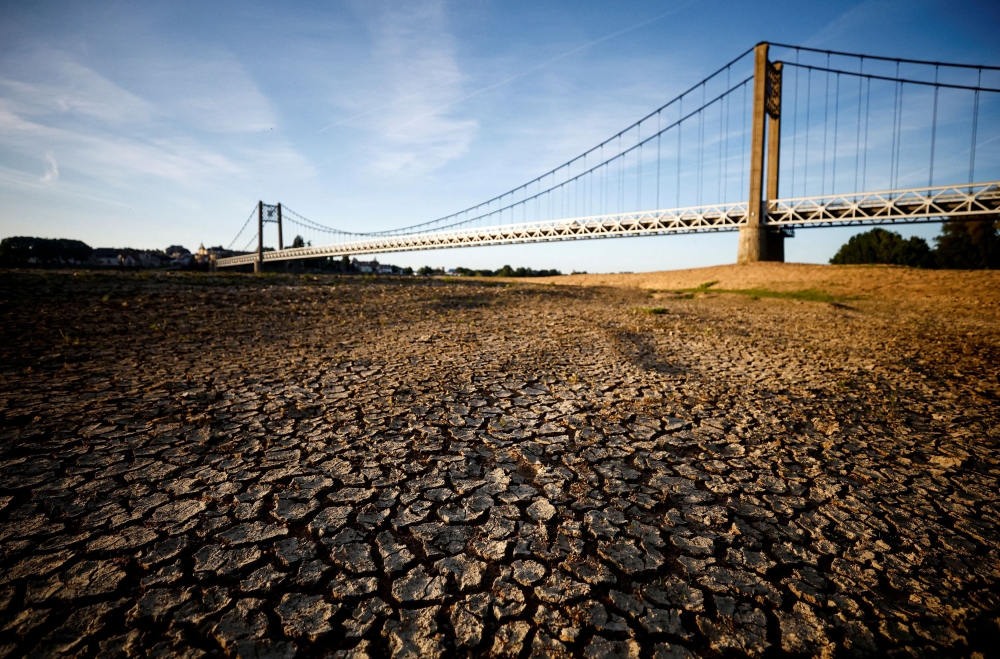 Cracked and dry earth is seen in the wide riverbed of the Loire River near the Anjou-Bretagne bridge as a heatwave hits France. — Reuters pic