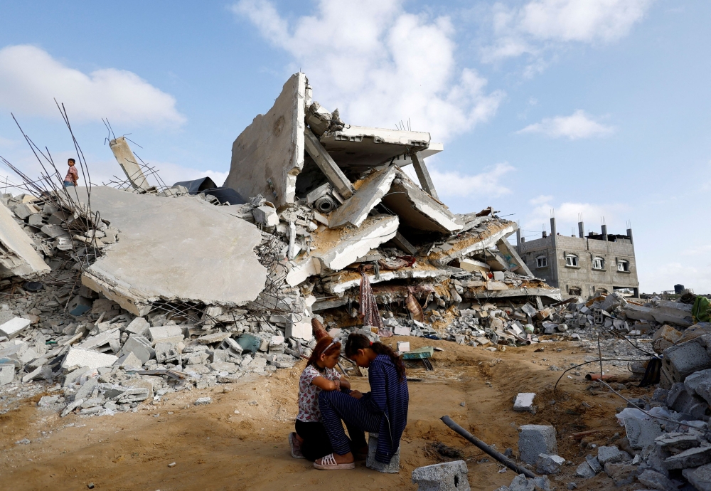 Palestinian children sit next to the site of an Israeli strike on a house, amid the ongoing conflict in the southern Gaza Strip, April 21, 2024. — Reuters pic