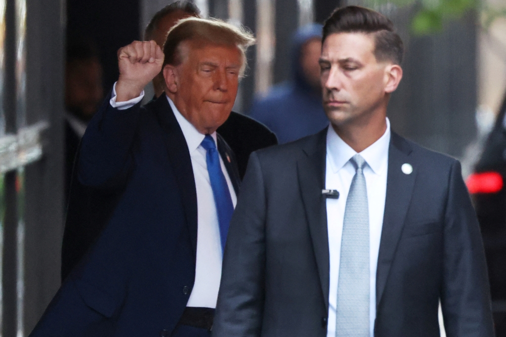 Republican presidential candidate and former US President Donald Trump gestures as he departs Trump tower in Manhattan to attend his criminal trial over charges that he falsified business records to conceal money paid to silence porn star Stormy Daniels in 2016, in New York City, April 22, 2024. — Reuters pic