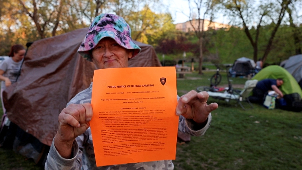 An unhoused woman named Kimberly Morris holds up a notice a police officer gave her giving her 72 hours to move her tent from the park, in Grants Pass, Oregon April 18, 2024. — Reuters pic