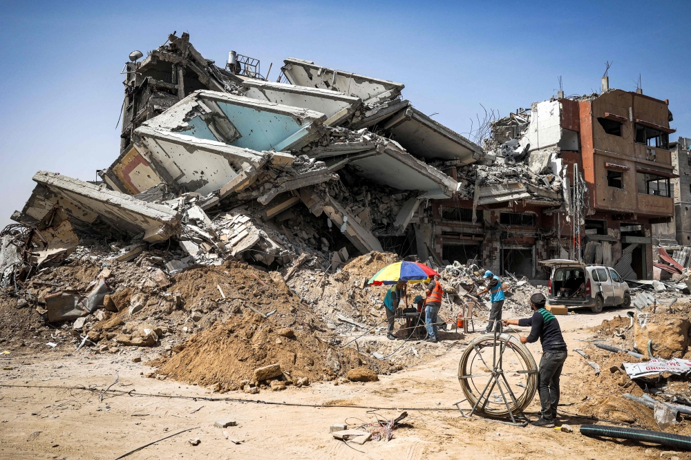 Salvage workers operate at the site of a destroyed building in Khan Yunis in the southern Gaza Strip on April 22, 2024 amid the ongoing conflict in the Palestinian territory between Israel and the militant group Hamas. — AFP pic