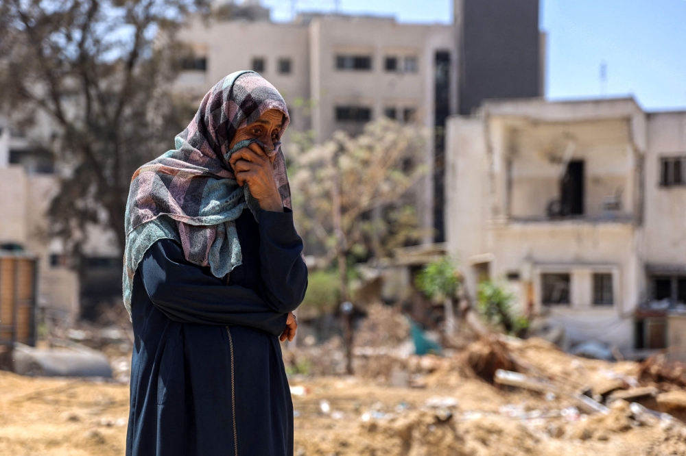 A woman reacts as she watches Palestinian forensic experts and others search for bodies of dead people in the vicinity of Al-Shifa Hospital in Gaza City on April 17, 2024 after the recent Israeli military operation there amid the ongoing fighting in the Palestinian territory between Israel and Hamas. — AFP pic