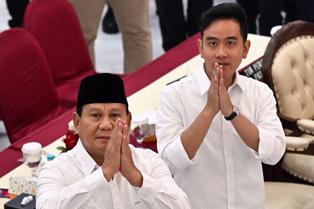 President-elect Prabowo Subianto (left) and vice president-elect Gibran Rakabuming Raka gesture as they arrive during the plenary meeting of general election commission (KPU) relating to the 2024 presidential election in Jakarta on April 24, 2024. — AFP pic