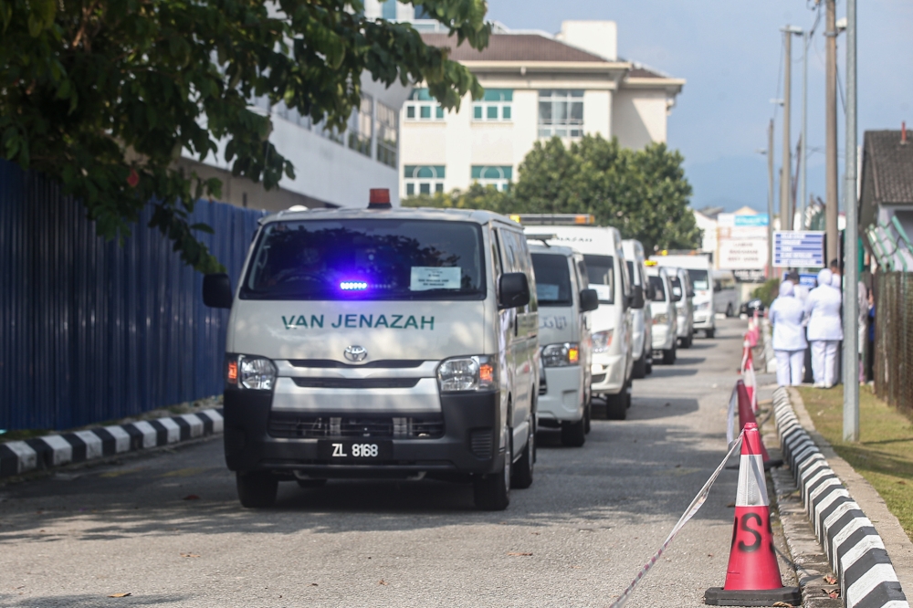 Vans carrying the bodies of the 10 navy personnel who died after two helicopters crashed during a training for a flyover for the 90th Navy Day celebration leaving the Hospital Raja Permaisuri Bainun mortuary following the completion of their post-mortems, April 24, 2024. — Picture by Farhan Najib