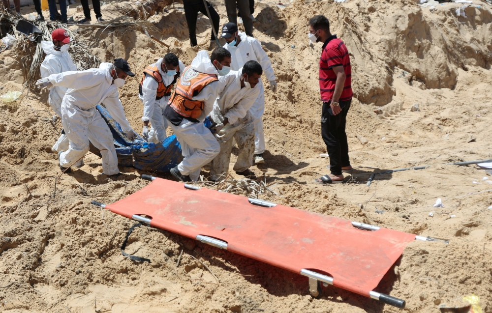 People work to move into a cemetery bodies of Palestinians killed during Israel's military offensive and buried at Nasser hospital, amid the ongoing conflict between Israel and the Palestinian Islamist group Hamas, in Khan Younis in the southern Gaza Strip, April 21, 2024. — Reuters pic