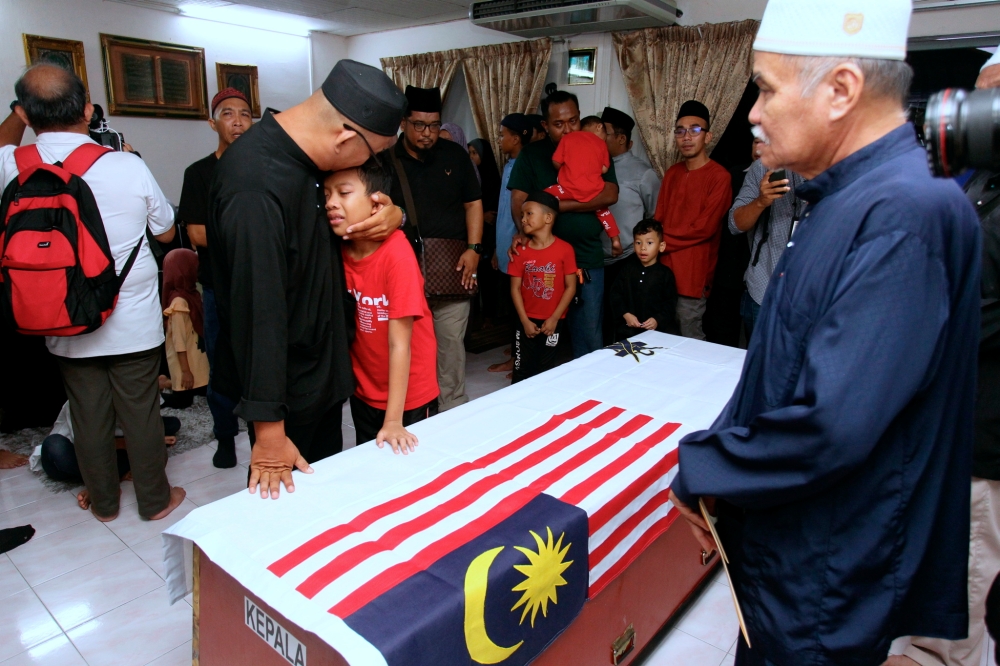 The late Warrant Officer II TMK Mohd Shahrizan Mohd Termizi was given final respects by family members and relatives in a solemn atmosphere at the residence of his father Mohd Termizi Abdul Ghani, 68, (right) in Taman Bunga Tanjung Lekir, Lumut, April 24, 2024. — Bernama pic 