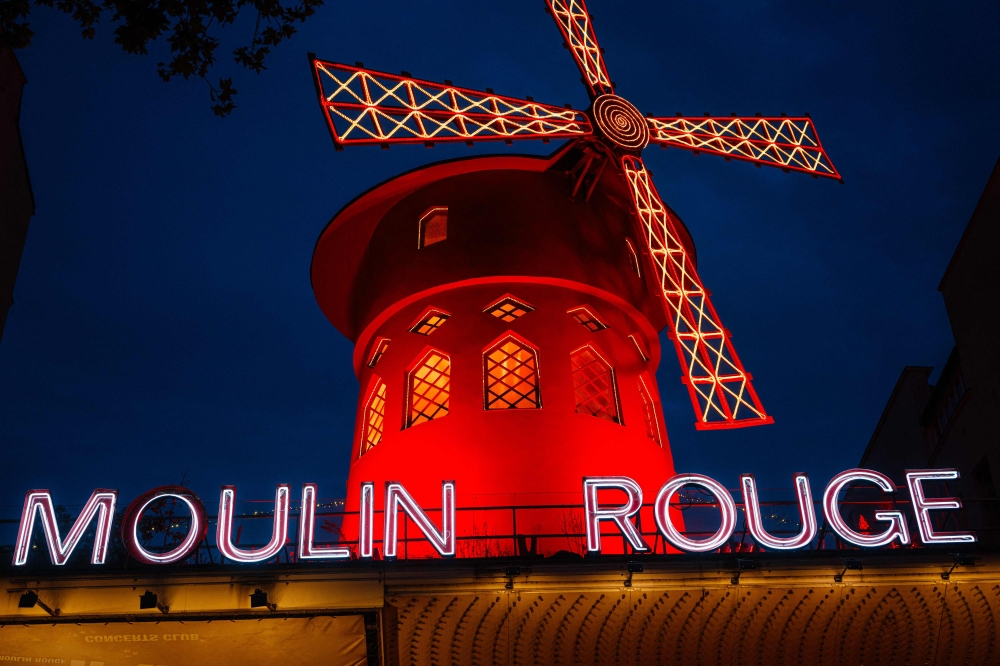 This photograph taken on October 13, 2023, shows the Moulin Rouge, a famous cabaret and theatre at night in Paris. — AFP pic