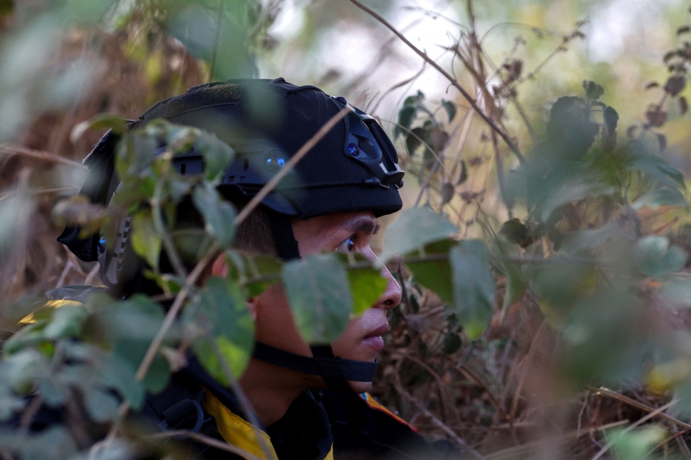 A Thai soldier takes cover near the 2nd Thailand-Myanmar Friendship Bridge during fighting on the Myanmar side between the Karen National Liberation Army (KNLA) and Myanmar's troops, which continues near the Thailand-Myanmar border, in Mae Sot, Tak Province,  Thailand, April 20, 2024. — Reuters pic