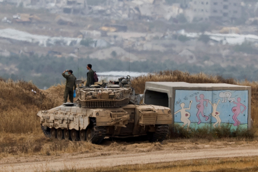 Israeli soldiers stand on a tank as they observe Gaza, amid the ongoing conflict between Israel and the Palestinian Islamist group Hamas, in Israel, April 25, 2024. — Reuters pic