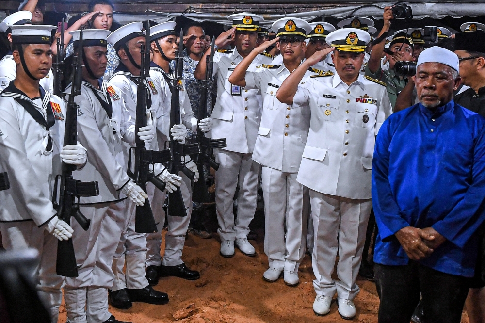 Assistant Chief of Staff for Warfare Communication and Information Systems, First Admiral Azman Rabani (second from the right), along with other TLDM officers pay their final respects to the late Lieutenant Commander Mohammad Amirulfaris Mohamad Marzukhi at the Senawang Muslim Cemetery, Negeri Sembilan, April 24, 2024. — Bernama pic 