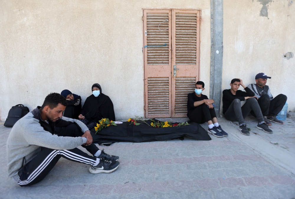 Mourners react as people work to move into a cemetery bodies of Palestinians killed during Israel's military offensive and buried at Nasser hospital, amid the ongoing conflict between Israel and the Palestinian Islamist group Hamas, in Khan Younis in the southern Gaza Strip, April 21, 2024. — Reuters pic