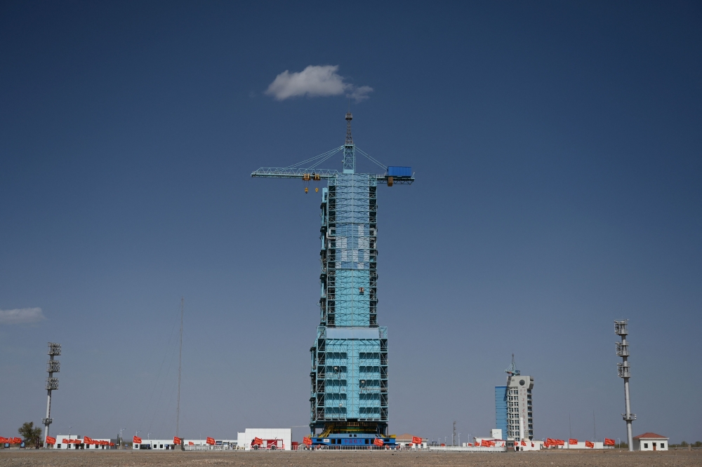 A Long March-2F carrier rocket, carrying the Shenzhou-18 spacecraft, is seen encased in a shield on the launch pad a day before the launch of the mission at the Jiuquan Satellite Launch Centre in the Gobi desert April 24, 2024. — AFP pic