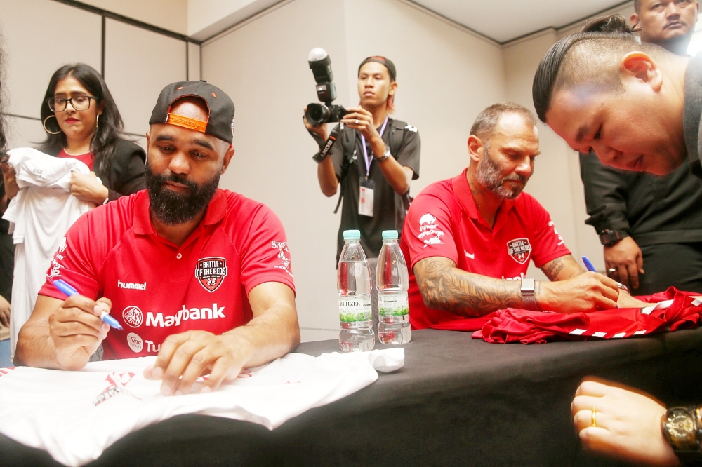 Berger and Sinama signing autographs for fans at the Meet the Red Legends lunch session. — Picture by Choo Choy May 