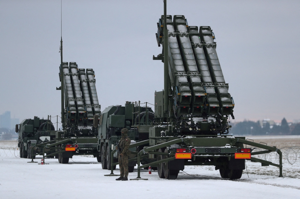 Serviceman patrols in front of the Patriot air defence system during Polish military training on the missile systems at the airport in Warsaw February 7, 2023. — Reuters pic  