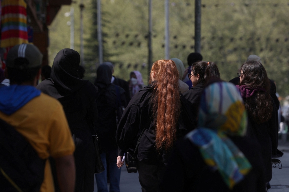 Iranian women walk on a street amid the implementation of the new hijab surveillance in Tehran, Iran, April 15, 2023. — Majid Asgaripour/Wana (West Asia News Agency) pic via Reuters 
