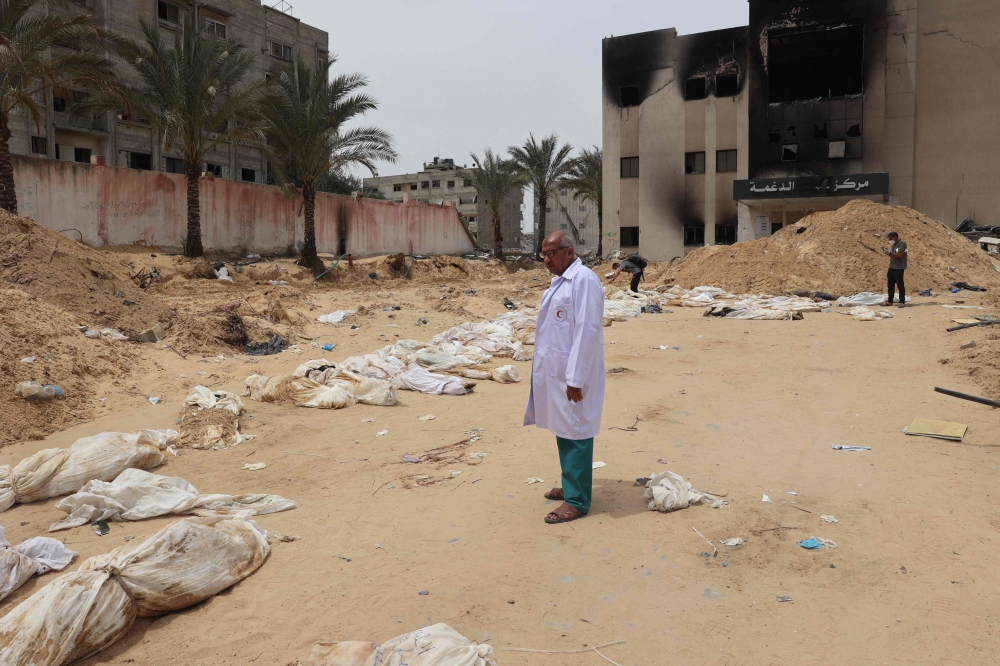 A doctor stands near bodies lined up for identification after they were unearthed from a mass grave found in the Nasser Medical Complex in the southern Gaza Strip on April 25, 2024. The head of Gaza’s Civil Defence agency in Khan Yunis, raised to 392 the number of bodies he said had been recovered from three mass graves at the city’s Nasser Medical Complex. — AFP pic 