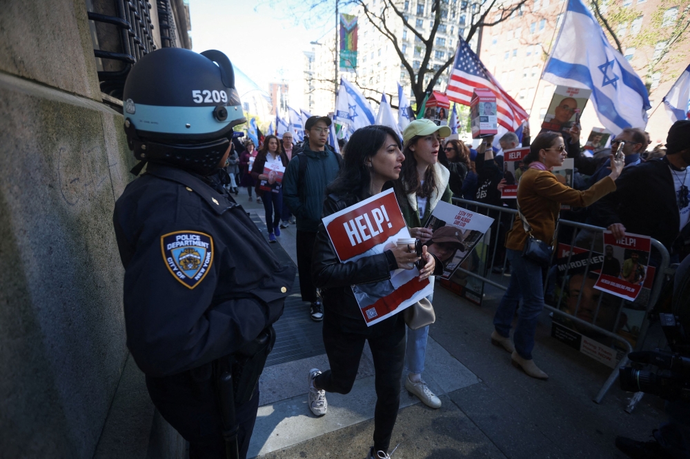 A New York City Police Department officer looks on as People take part in a demonstration in support of Israel outside the Columbia University campus as student protest encampment in support of Palestinians continues, during the ongoing conflict between Israel and the Palestinian Islamist group Hamas, in New York April 26, 2024. — Reuters pic