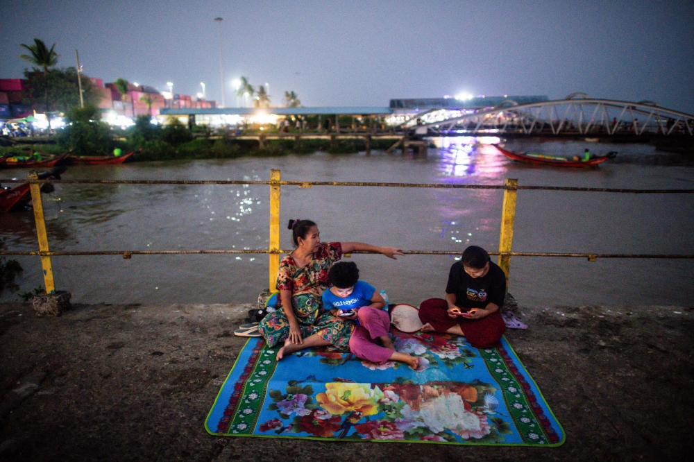 People gather at a jetty during an electricity blackout in Yangon April 26, 2024. — AFP pic