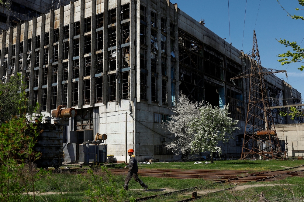 An employee walks in front of a thermal power plant damaged by recent Russian missile strikes, amid Russia's attack on Ukraine, in an undisclosed location in Ukraine April 12, 2024. Ukraine has lost about 80 per cent of its thermal generation and about 35 per cent of its hydropower capacity, officials aid. — Reuters pic