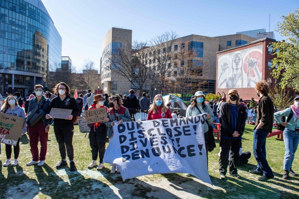 Pro-Palestinian protesters hold a banner and create a human chain around an encampment set up at Northeastern University in Boston, Massachusetts, on April 25, 2024. — AFP pic
