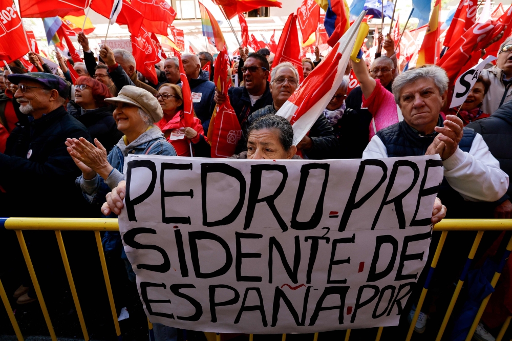 A supporter holds a sign reading ‘Pedro, president of Spain’ during a demonstration called in support of the Spanish Prime Minister, in front of the PSOE party headquarters in Madrid, on April 27, 2024. — AFP pic