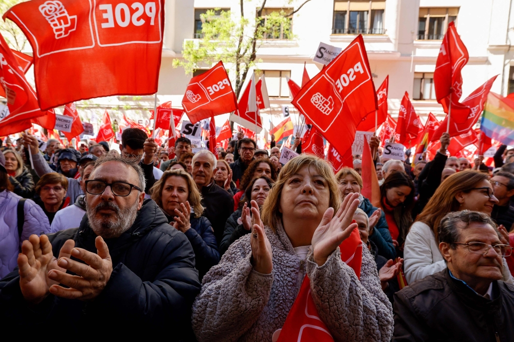 Supporters gesture and wave flags during a demonstration called in support of the Spanish Prime Minister, in front of the PSOE party headquarters in Madrid, on April 27, 2024. — AFP pic