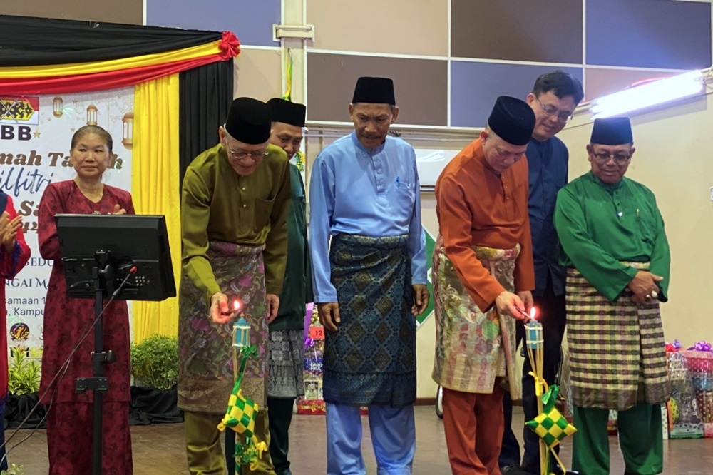 Deputy Prime Minister Datuk Seri Fadillah Yusof (2nd right) lights up the lamps with Satok assemblyman Datuk Ibrahim Baki (2nd left) during the PBB Satok Aidilfitri gathering. — Nur Shazreena Ali/The Borneo Post pic 