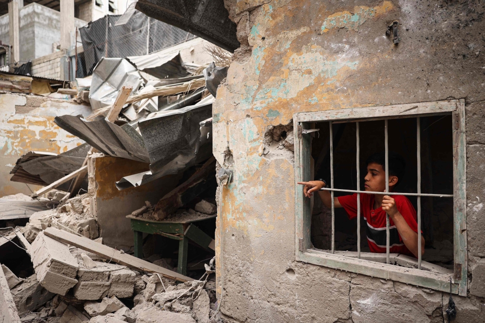 A Palestinian child stands amid the debris of a house destroyed by overnight Israeli bombardment in Rafah in the southern Gaza Strip on April 27, 2024. — AFP pic 