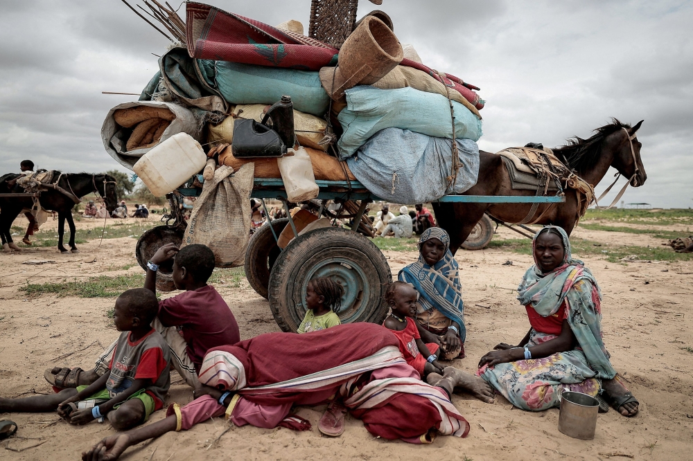 File picture of a Sudanese family who fled the conflict in Murnei in Sudan’s Darfur region, sitting beside their belongings while waiting to be registered by UNHCR upon crossing the border between Sudan and Chad in Adre, Chad, July 26, 2023. — Reuters pic 