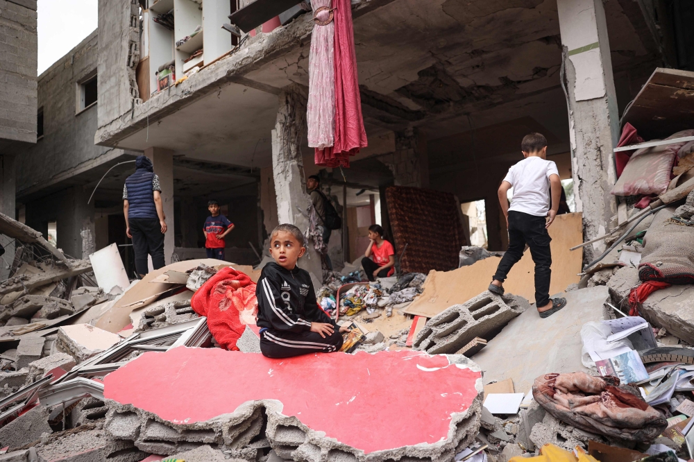 Palestinian children walk amid the debris of a house destroyed by overnight Israeli bombardment in Rafah in the southern Gaza Strip on April 27, 2024. — AFP pic 