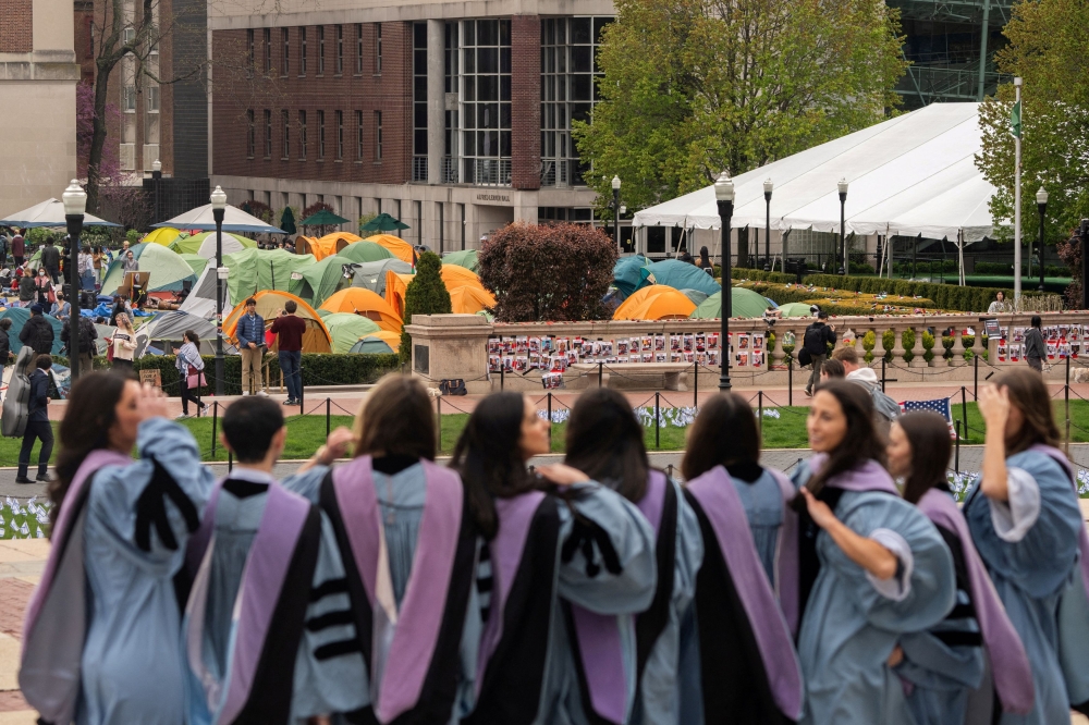Students wearing gowns stand as students continue to maintain a protest encampment on the main campus of Columbia University in support of Palestinians, in New York City, April 27, 2024. — Reuters pic 