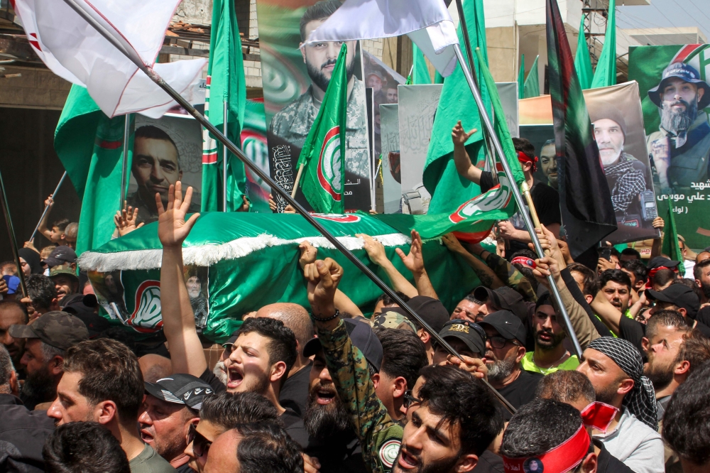 Mourners carry the casket Shia Amal movement commander Wassim Moussa, who was killed during an Israeli airstrike on April 20, during his funeral in the southern Lebanese village of Kfar Kila on April 23, 2024. — AFP pic 