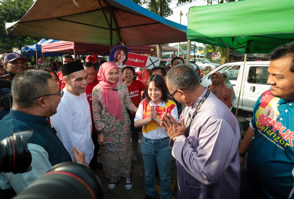 Pakatan Harapan (PH) candidate Pang Sock Tao greets Perikatan Nasional (PN), Khairul Azhari Saut, at the Batang Kali morning market. — Bernama pic