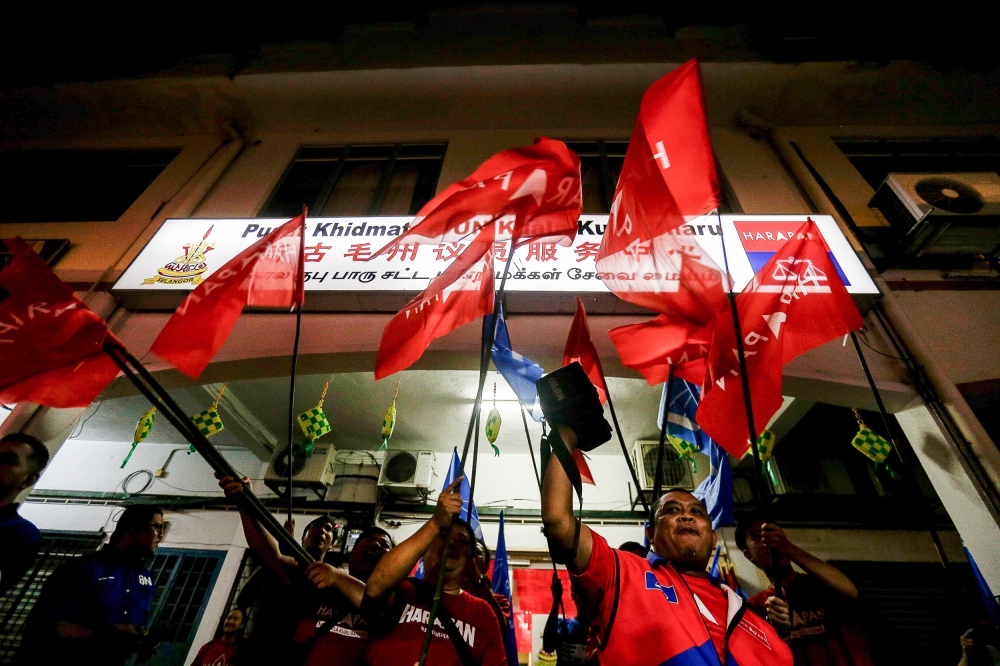 Supporters wave Pakatan Harapan and Barisan Nasional flags during the announcement of Kuala Kubu Baru by-election candidate at the DAP Operation Centre in Kuala Kubu Baru April 24, 2024. PH would retain the seat with an overall turnout of 58 per cent and if Chinese support reaches 90 per cent, Indian support 80 per cent and Malay support at just 20 per cent, Ong estimated. — Picture by Sayuti Zainudin