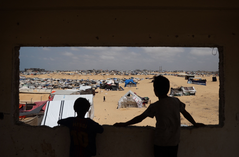 Palestinian children stand in a camp for displaced people in Rafah in the southern Gaza Strip by the border with Egypt on April 28, 2024, amid the ongoing conflict between Israel and the Palestinian militant group Hamas. — AFP pic